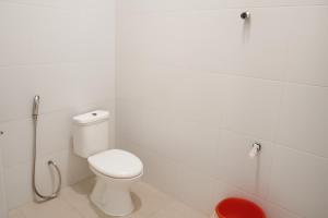 a white bathroom with a toilet and a shower at Luxe5 Inn Hj Hasnah Hasan in Takengon +1 photo