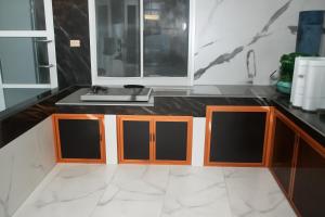 a kitchen counter with a sink and a mirror at Luxe5 Inn Hj Hasnah Hasan in Takengon