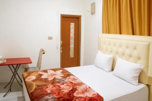 a bedroom with a bed and a desk and a table at Luxe5 Inn Hj Hasnah Hasan in Takengon