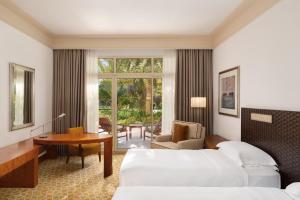 a hotel room with two beds and a desk at Grand Hyatt Doha Hotel & Villas in Doha +135 photos