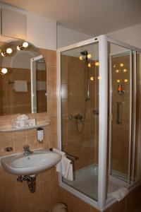 La salle de bains est pourvue d'un lavabo et d'une douche. dans l'établissement STADT-Hotel Lörrach GbR, à Lörrach