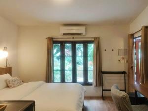 a bedroom with a bed and a large window at Fern House Retreat in Chalong  +32 photos