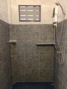 a shower in a bathroom with a window at Fern House Retreat in Chalong 