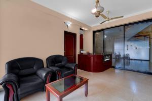 a living room with two chairs and a coffee table at Collection O KSRTC Bus Station Kottayam Formerly Hotel O Day Springs in Kottayam