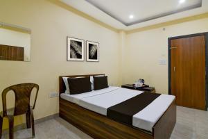 a bedroom with a bed with a chair and a door at Collection O Asian Highway Near Agrasen Hospital Siliguri Formerly Ashiyana Homestay in Binnāguri