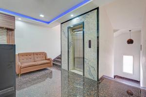 Una sala de estar con un sofá y una puerta de cristal. en Townhouse Vanagaram Apollo Hospital Chennai Formerly V Hotels & Restaurant, en Chennai