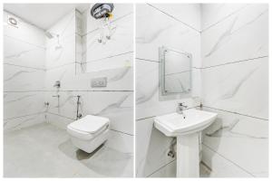 a white bathroom with a toilet and a sink at Townhouse Sector 102 Noida in Noida
