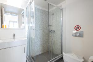 a bathroom with a shower and a toilet and a sink at Renovated 4 Bdr House near Acropolis - New Beds, Terrace & Green Yard in Athens +42 photos