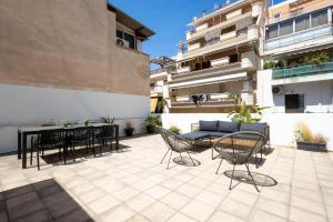 a patio with chairs and a table and a couch at Renovated 4 Bdr House near Acropolis - New Beds, Terrace & Green Yard in Athens