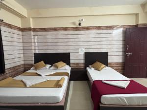 2 camas en una habitación con pared en Yammuna Vihaar Tourist Home, en Kollūru