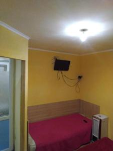 Un dormitorio con una cama y un televisor en la pared. en 1 комн квартира, свой двор, en Cherkasy