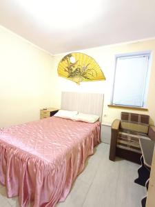 1 dormitorio con cama rosa y ventana en 1 комн квартира, свой двор, en Cherkasy