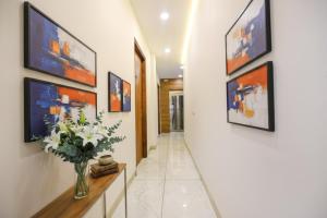 a hallway with paintings on the wall and a vase with flowers at FabHotel Globe Inn in Ludhiana