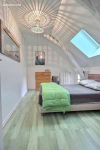 - une chambre mansardée avec un lit et une commode dans l'établissement Le Clos Fleuri, à Pontiacq-Viellepinte