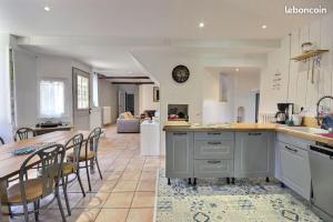 une cuisine et un salon avec une table et des chaises dans l'établissement Le Clos Fleuri, à Pontiacq-Viellepinte