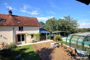 Elle offre une vue sur l'extérieur d'une maison dotée d'une terrasse. dans l'établissement Le Clos Fleuri, à Pontiacq-Viellepinte 2 autres photos