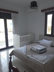 Un dormitorio con dos camas en una habitación con ventanas. en Magy's house, en Batsi