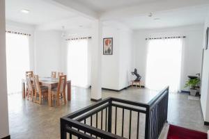 a dining room with a table and chairs and windows at Grand Castellea Resort in Wattegama