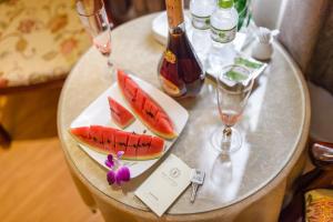 a table with a plate of fruit and wine glasses at Iris Hotel Đà Nẵng in Danang