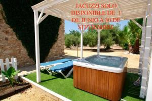 pérgola con bañera de hidromasaje en un patio en Cau d'Amor, en L'Ampolla