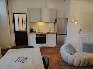 Il comprend une cuisine équipée d'une table et d'un canapé. dans l'établissement Authentique Bouquet, au Mans