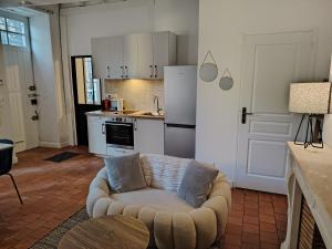 un salon avec un canapé et une cuisine dans l'établissement Authentique Bouquet, au Mans