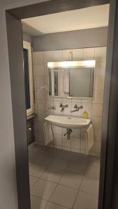 łazienka z umywalką i lustrem w obiekcie Hotel Check Inn Sumak w mieście Bassersdorf