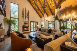 Una sala de estar con sofás y chimenea. en Karongwe - Kuname Safari Lodge, en Hoedspruit