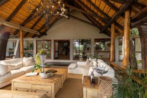 una sala de estar con un sofá y una mesa en Karongwe - Kuname Safari Lodge, en Hoedspruit