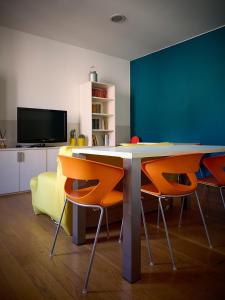 a dining room with a table and orange chairs at L'Archetto in Cremona