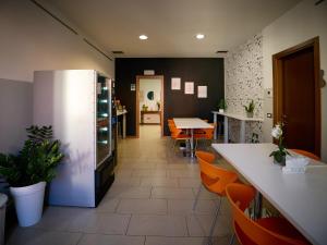 a kitchen with orange chairs and a refrigerator at L'Archetto in Cremona
