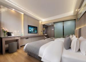 Una habitación de hotel con una cama grande y un televisor. en Yiyun Residence, en Hanqiyu