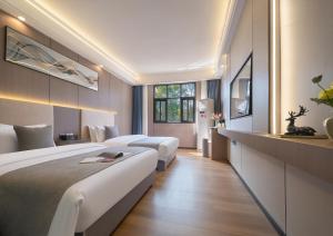 Una habitación de hotel con dos camas y una ventana. en Yiyun Residence, en Hanqiyu