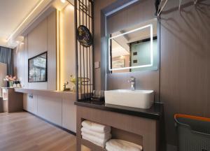 un baño con lavabo y espejo en Yiyun Residence, en Hanqiyu