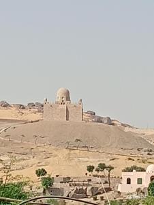 阿斯旺Sugar Nubian Guest House Nile Vew的沙漠山顶上的一座清真寺