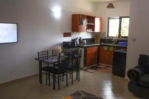 una cucina con un tavolo e sedie in una stanza di Treasured Haven Stay a Ukunda Altre 32 foto