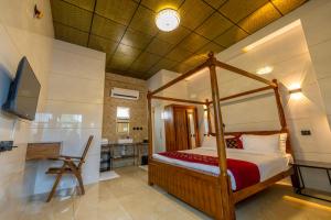 a bedroom with a canopy bed and a kitchen at W H Nest Hostel in Cochin