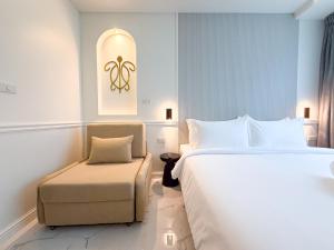 a hotel room with a bed and a chair at Laoteng Boutique Hotel in Phuket Town +15 photos