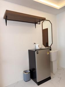 a room with a refrigerator and a mirror on the wall at Laoteng Boutique Hotel in Phuket Town