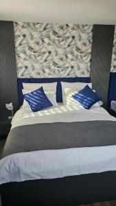 sypialnia z łóżkiem z niebieskimi i białymi poduszkami w obiekcie Hotel Check Inn Sumak w mieście Bassersdorf