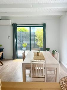 金斯顿Little Red Gate Urban Retreat的一间有白色桌子和椅子的餐厅