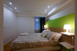 a bedroom with a bed with a green wall at La Tana di Alice in Muggia