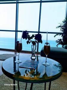 due bicchieri da vino e un vaso con fiori su un tavolo di Sara and Bora a Durrës