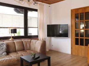 a living room with a couch and a tv at Fewo Wrede am Sauerland-Radring in Wenholthausen