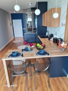 eine Küche mit einem Holztisch mit Stühlen und einer Theke in der Unterkunft Sara and Bora in Durrës