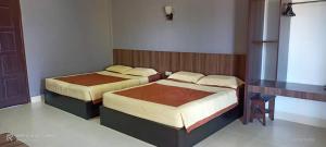a bedroom with two beds in a room at Baiduri's Place in Pantai Cenang +12 photos
