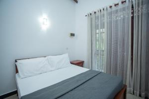 哈巴拉杜瓦Villa Aliya的一间卧室，有一张白色的床和一扇窗户 更多29张照片