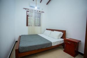 哈巴拉杜瓦Villa Aliya的一间带床和床头柜的小卧室