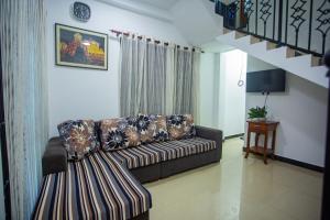 ein Wohnzimmer mit einer Couch und einer Treppe in der Unterkunft Villa Aliya in Habaraduwa Central