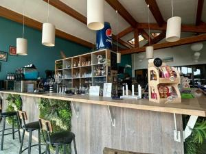 a bar in a restaurant with stools at MH539 La Cabane des vagues in Saint-Julien-en-Born